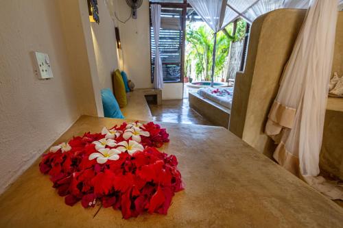 a bouquet of red and white flowers on a table at Zoi Boutique Hotel Zanzibar ex Sunshine Hotel in Matemwe