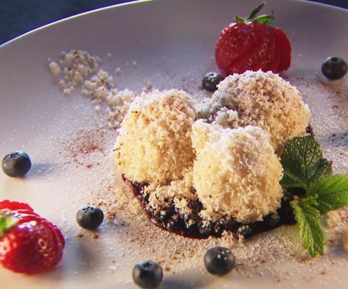 a white plate with a dessert with strawberries and blueberries at Naturhotel Hüttenwirt im Grossarltal in Hüttschlag