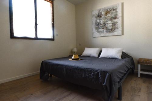 a bedroom with a bed with a blue blanket and two windows at LE GALLI en plein cœur de Sanary in Sanary-sur-Mer