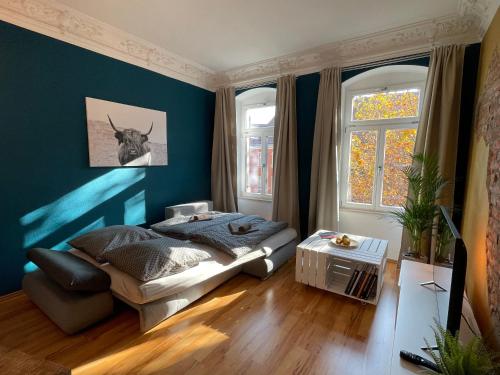 a bedroom with a bed and a blue wall at Edle Ferienwohnung - Industrial Style in Dresden