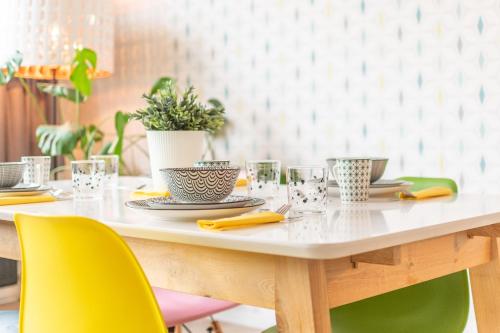 une table avec des chaises jaunes et une table blanche avec des verres dans l'établissement VilvoCity Center, à Vilvorde