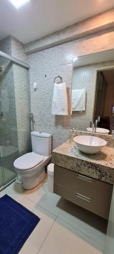 a bathroom with a toilet and a sink at Flat Tabatinga Nord, vista para o mar in Conde