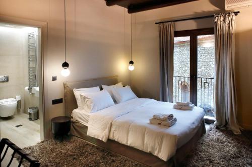 a bedroom with a large bed and a bathroom at Anesis Hotel in Kalavrita