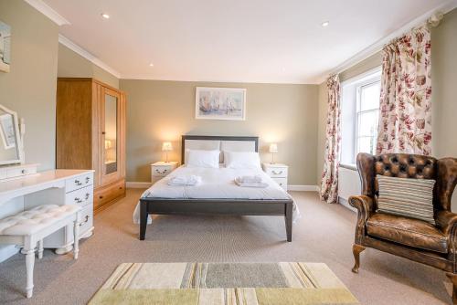 ein Schlafzimmer mit einem Bett und einem Stuhl in der Unterkunft 4 Market Cross House Aldeburgh Air Manage Suffolk in Aldeburgh