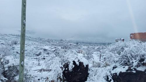a field covered in snow with a mountain in the background at Cabañas La Rústica in Bialet Massé