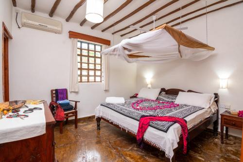 a bedroom with a bed in a room at Eden House Cottages in Malindi