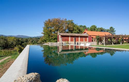 a house with a pond in front of it at Quinta De Vila Nova - Agroturismo in Monção