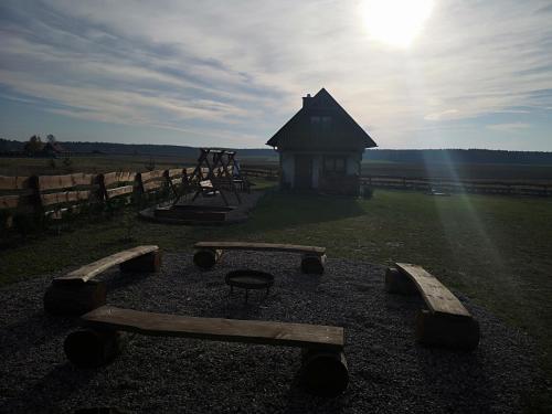 a playground with a small building in the middle of a field at Domek u Lipków na Kaszubach "Iga" JACUZZI in Lipusz
