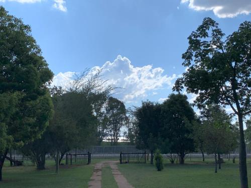a park with trees and a fence in the background at Sunset Guesthouse and Venue Cullinan in Meule