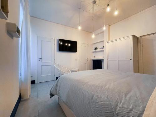 1 dormitorio con 1 cama blanca y TV en la pared en Guest House S.Caterina, en Viterbo