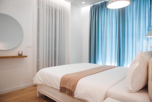 een slaapkamer met een bed en een raam met blauwe gordijnen bij TAM Serviced Apartment City Center No4 in Tirana