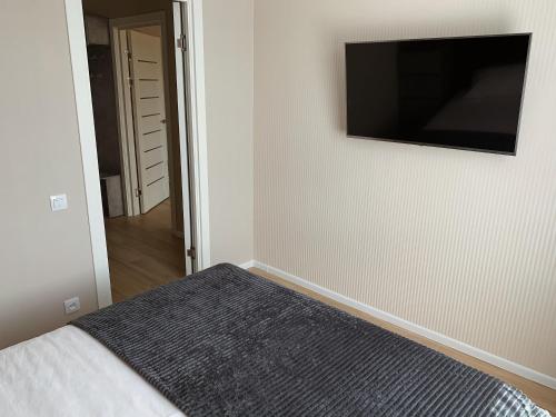 a bedroom with a bed and a flat screen tv on the wall at Апартаменты на Гагарина in Cherkasy