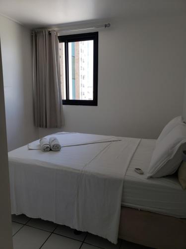 - une chambre avec un lit blanc et une fenêtre dans l'établissement APT TOP BEIRA MAR NEO 2.0, à Maceió