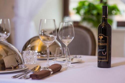a bottle of wine sitting on a table with two wine glasses at Hotel Alter in Lublin