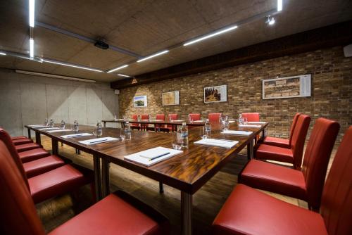 a conference room with a long table and red chairs at Hotel Alter in Lublin