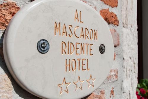 un panneau indiquant un hôtel de refuge de canyons masoniques sur un mur de briques dans l'établissement Al Mascaron Ridente, à Venise