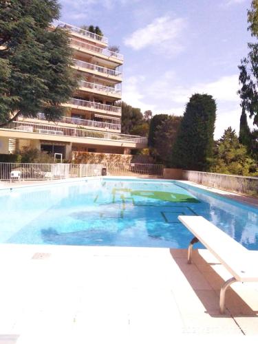 une grande piscine avec un bâtiment en arrière-plan dans l'établissement NICE- GAIRAUT - JARDIN PRIVE- GRAND F1 LUMINEUX-Piscine Collective, à Nice