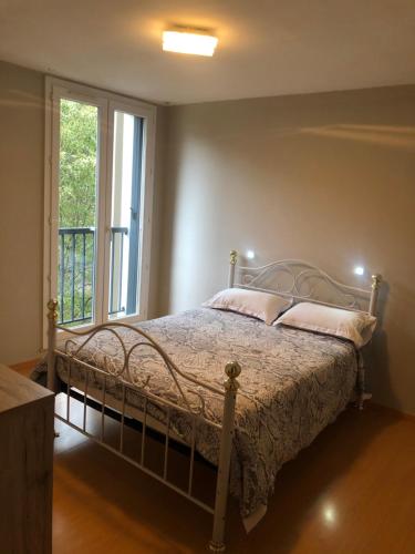 Cama en habitación con ventana y cama sidx sidx sidx sidx en Appartement VUE MER avec parking gratuit sur place, en Bastia