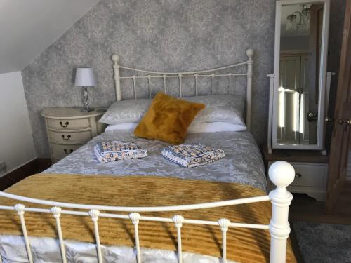 a bedroom with a bed with two pillows on it at Wisteria house in Plymouth