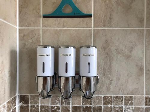 three coffeemakers sitting on a wall in a bathroom at Wisteria house in Plymouth