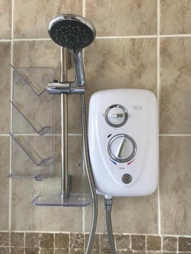 a shower with a hair dryer attached to a wall at Wisteria house in Plymouth