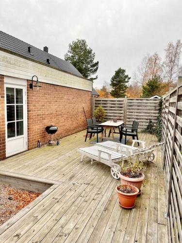 a wooden deck with a table and chairs on it at Båstad in Båstad