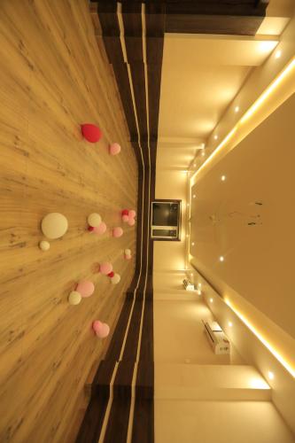 a hallway with a wall with pink dots on it at Hotel Buddha House Himalayan Brothers in Dharamshala