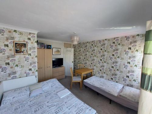 a bedroom with two beds and a table and a dining room at Home accommodation in Southampton