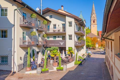 a street in a town with a clock tower at Hotel Goldene Traube in Termeno