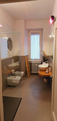 uma casa de banho com 2 lavatórios, uma banheira e uma janela em B&B Panemiele em Sondrio