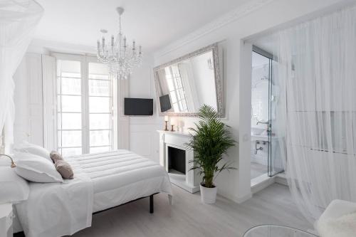 a white bedroom with a bed and a fireplace at Urban Suite Santander in Santander