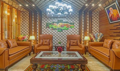 a waiting room with brown leather chairs and a table at Hotel Woodville Inn - Hotel in Mcleodganj in McLeod Ganj