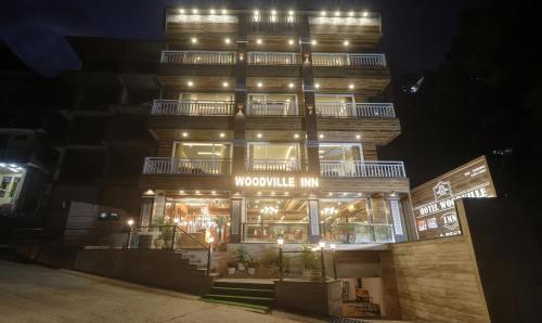 a large building with lights on it at night at Hotel Woodville Inn Mcleodganj in McLeod Ganj