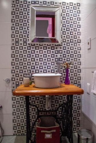 a bathroom with a sink and a mirror on a table at Cane B&B in Montevideo