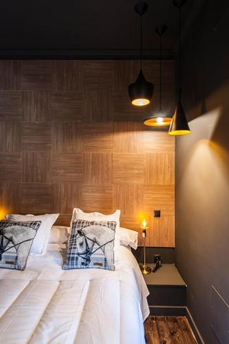 a bedroom with a large white bed with wooden walls at Urban Suite Santander in Santander