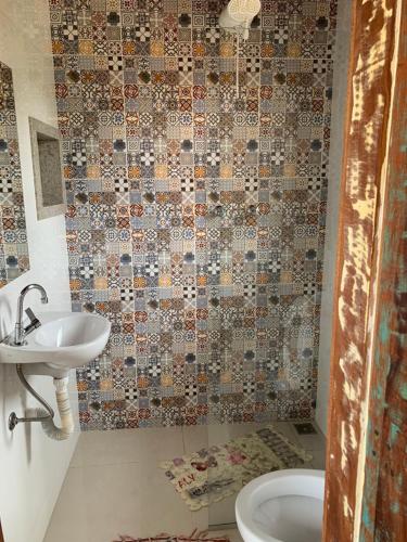 a bathroom with a toilet and a sink and a shower at Pousada Sossego in Lavras Novas