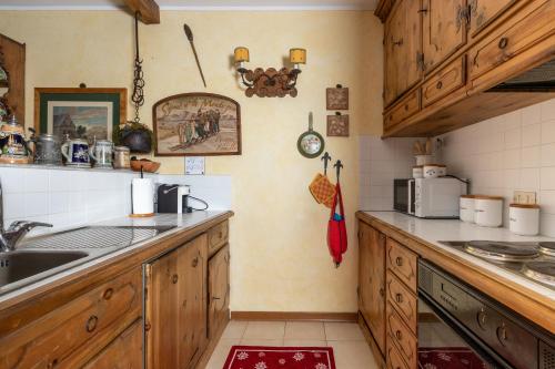 a kitchen with wooden cabinets and a sink at Chalet Casericc in Bormio