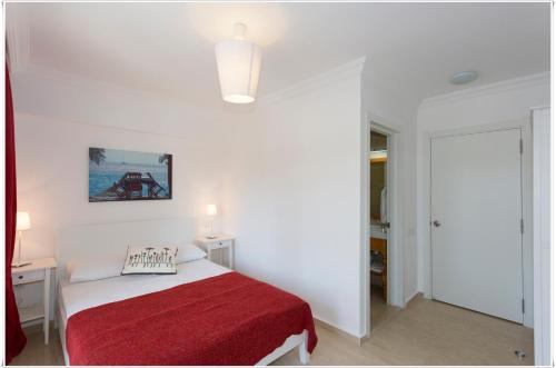 a white bedroom with a bed with a red blanket at Ayka Hotel in Akyaka