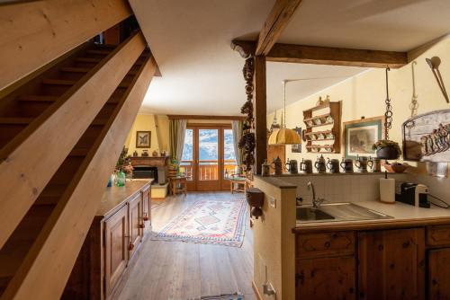 a kitchen with wooden floors and a staircase with a sink at Chalet Casericc in Bormio