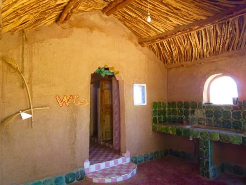 a room with a window and a room with green tiles at Chez Madani in Mhamid