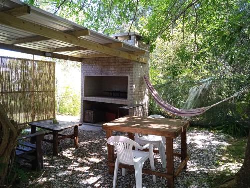 un patio con mesa, sillas y chimenea en Gotas de Rocio x 4 - Hojas de Otoño x 2, en Piriápolis