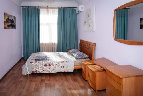 een slaapkamer met een bed, een spiegel en een raam bij Apartments on Gogolya, 14a in Dnipro