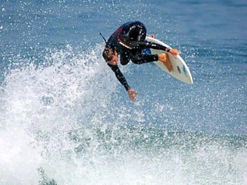 a man riding a wave on a surfboard in the ocean at Olhar da Barra Hospedagem - Refugio Urbano I in Florianópolis