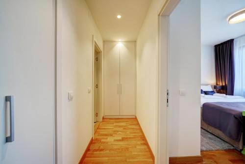 a corridor of a room with a bed and a door at Beograd na vodi - Belgrade Waterfront Riverside in Belgrade