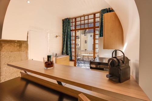 a kitchen with a wooden table in a room at La Terrasse du Thiou - Location in Annecy