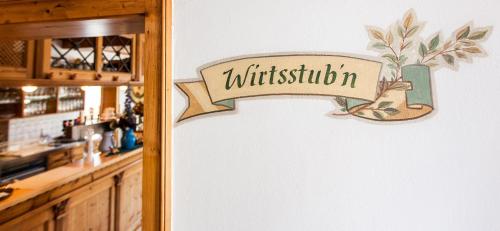 a sign for a restaurant on a wall at Landhotel Gasthof Huber in Merching