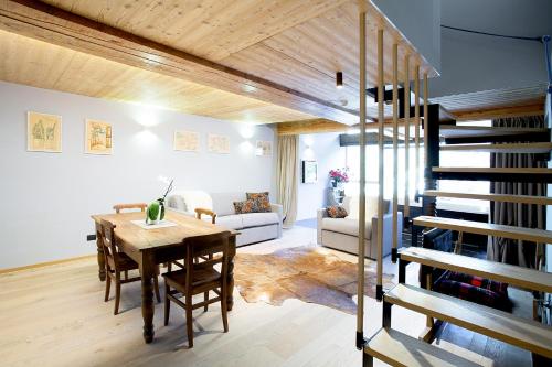 ein Wohnzimmer mit einem Holztisch und einer Wendeltreppe in der Unterkunft Aux Pieds du Roi - Suite & Spa in Breuil-Cervinia