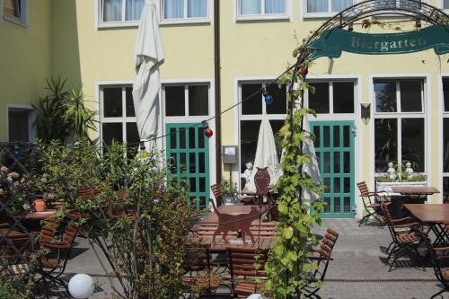 an outdoor patio with tables and an umbrella at Landhotel Gasthof Huber in Merching