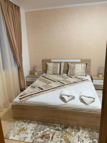 a bedroom with a bed with white sheets and pillows at Гранд Манастира , Пампорово in Pamporovo
