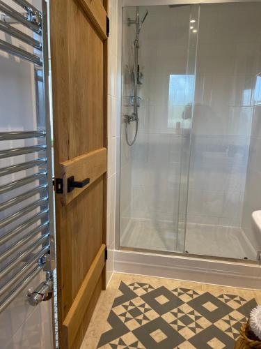 uma casa de banho com um chuveiro e uma porta de vidro em NEW! Country boutique escape . HOT TUB em Weare Giffard